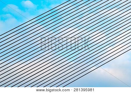 Parallel Guyes Of A Cable-stayed Bridge Located Diagonally Against A Blue And Cloudy Sky. Architectu