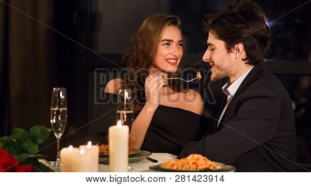 Romantic Couple Having Romantic Dinner In Restaurant, Feeding Each Other.