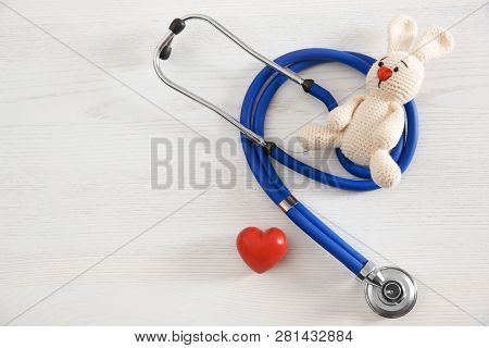 Toy Bunny, Stethoscope, Heart And Space For Text On White Wooden Background, Top View. Children's Do