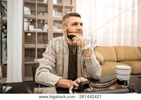Thoughtful Bearded Man Touching His Chin In Doubting Gesture