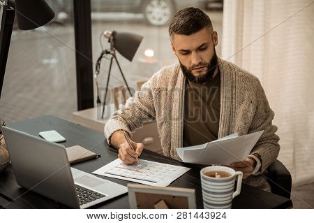 Confused Self-employed Bearded Man Flipping Through Papers