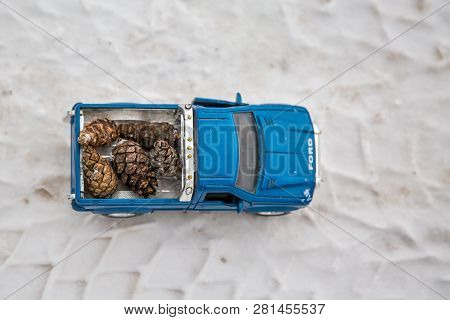 Moscow. January 2019. Top View Of Toy Ford F350 Pickup Truck On Winter Road. Carrying Fir Cones.  On