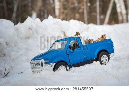 Moscow. December 2018. Blue Toy Pickup Truck Ford F350 In Snow Forest. Carrying Fir Cones. Winter Ro