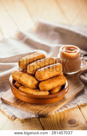 Cheese Fingers, Typical Venezuelan Appetizer Called Tequeños Accompanied With A Pink Sauce On A Wood