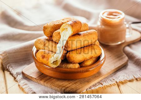 Cheese Fingers, Typical Venezuelan Appetizer Called Tequeños Accompanied With A Pink Sauce On A Wood