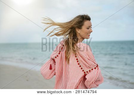 Funloving young woman lauhging at the beach