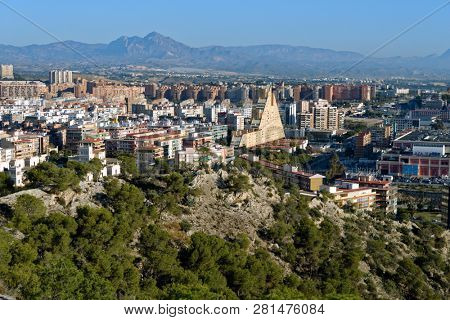 ALICANTE, SPAIN - JANUARY 8, 2013: Cityscape viewed from the Mount Benacantil. Pyramid-shaped building in center is Edificio Montreal, built in 1980s and referred as one of ugliest buildings in Spain