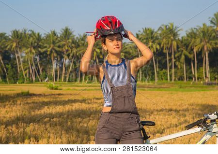 Cyclist Woman Putting Bike Helmet On - Head Protection On Outdoor Sport Activiy. Girl On Bicycle Dur