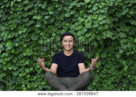 Smiling Asian Young Man In Black T-shirt Posing Yoga