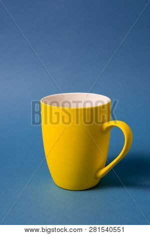 Big Yellow Empty Mug Isolated On Blue Background, Vertical.