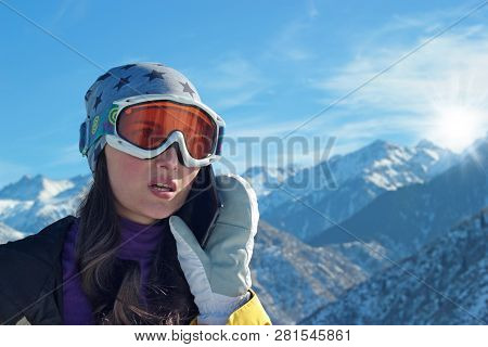 Girl In Ski Equipment With An Anxious Facial Expression Makes Phone Calls.