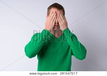 Young Handsome Man Covering Eyes As Three Wise Monkeys Concept