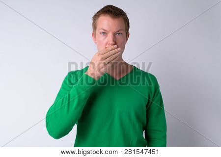 Young Handsome Man Covering Mouth As Three Wise Monkeys Concept