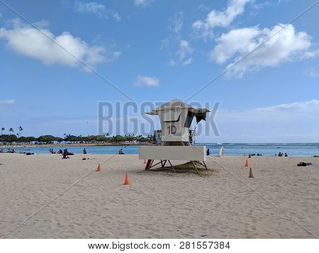 Honolulu - June 9, 2018:  Lifeguard Tower 1d And Surfboard At Ala Moana Beach With People Hanging Ou
