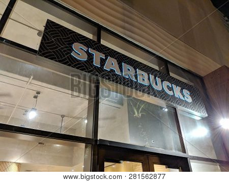 Waikiki - June 8, 2018:  Starbucks White Lettering Sign Above Store At Night.  Starbucks Corporation