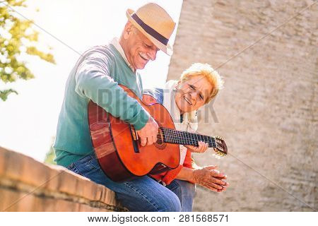 Happy Senior Couple Playing A Guitar And Having A Romantic Date Outdoor - Mature People Having Fun E