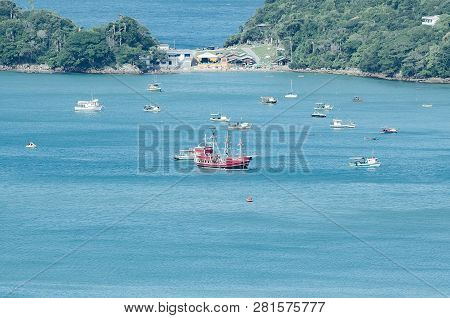 Bombinhas - Sc, Brazil - December 18, 2018: Touristic Red Ship Sailing In Front Of The Praia Da Sepu