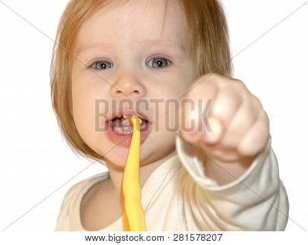 Little Baby Girl Dabbles And Has Fun While Learning To Brush Her First Teeth. The Child Shows The Fi
