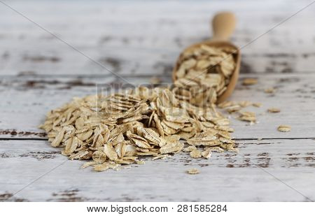 Dried Oats Or Oatmeal In Spoon On The Wood Table. Its Are A Nutrient-rich Food Associated With Prote