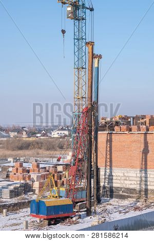 Crawler Cranes, Piles, Concrete Slabs And Cranes On The Construction Site Near The Multi-storey Buil
