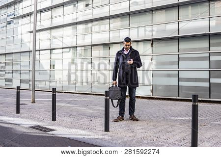 Middle Aged Man With A Briefcase And A Phone On The Street