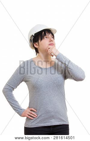 Ingenious Young Woman Engineer Wearing Protective Helmet Holding Hand Under Chin Looking Up Thinking