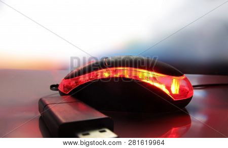Black Glowing Mouse And Flash Drive On The Table