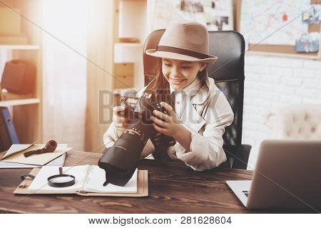 Private Detective Agency. Little Girl In Cloak And Hat Is Sitting At Desk Taking Notes In Notebook.