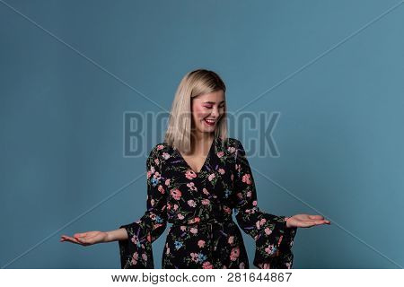 Blonde Young Woman In Spring Dress Showing Open Palm With Copy Space For Prodact