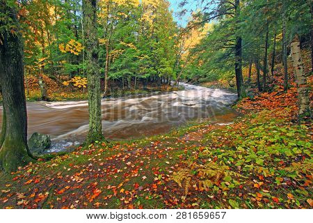 Rocky Cascades Of The Falls River Flow Through Bright Fall Foliage In Baraga County Michigan