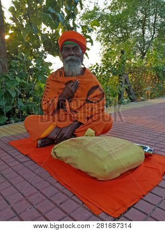 Tiruvanamalai, India - January 5, 2019: Sadhu sitting along the road in Tiruvanamalai India