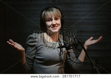 Confused Woman A Singer In A Headphones Is Guiltily Spreading Hands In A Sound Recording Studio Room