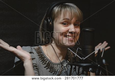 Confused Woman A Singer In A Headphones Is Guiltily Spreading Hands In A Sound Recording Studio Room