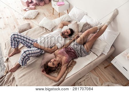 Pretty Long-haired Blond Woman Touching Her Dark-haired Husband Tenderly