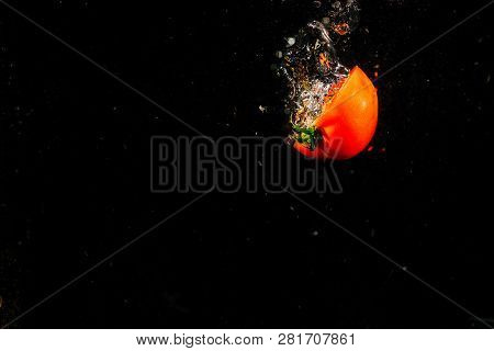 Half Of Tomato Falls On Black Background