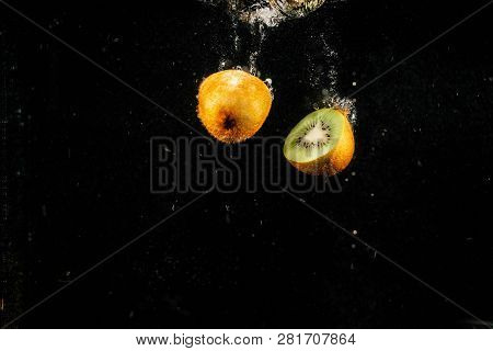 Half Of Kiwi Falling On Black Background
