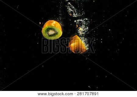 Halves Of Green Kiwi Fall In Aquarium