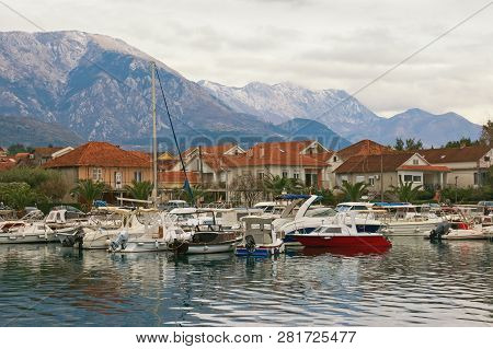 Cloudy Winter Day. Small Marina For Fishing Boats At Foot Of Mountains.   Montenegro, Bay Of Kotor. 