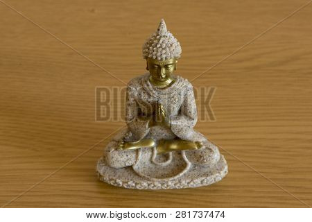 The Figure Of A Buddha On A Brown Background