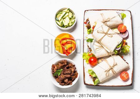 Burritos Tortilla Wraps With Ingredients - Beef And Vegetables On White Table.  Traditional Latin Am