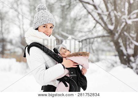 Little Baby Girl And Her Mother Walking Outside In Winter Mother Is Holding Her Baby Babywearing In 
