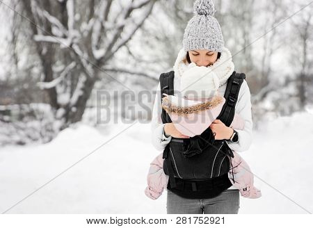 Little Baby Girl And Her Mother Walking Outside In Winter Mother Is Holding Her Baby Babywearing In 