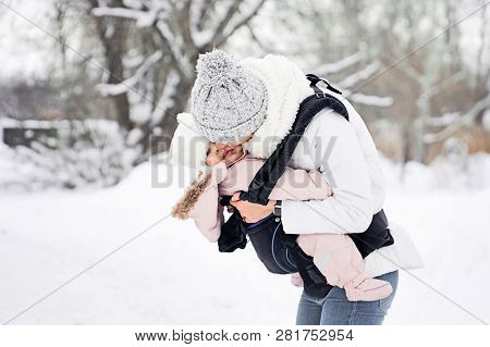 Little Baby Girl And Her Mother Walking Outside In Winter Mother Is Holding Her Baby Babywearing In 