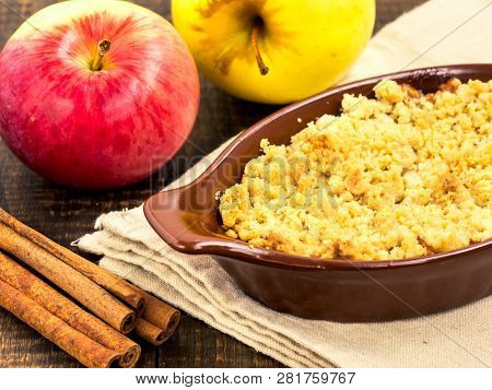 Homemade Apple Cramble Cake With Fresh Apples And Cinnamon Sticks On Rustic Dark Wooden Background