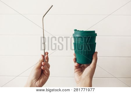 Hands Holding Stylish Reusable Eco Coffee Cup And Steel Straw On White Wooden Background. Zero Waste