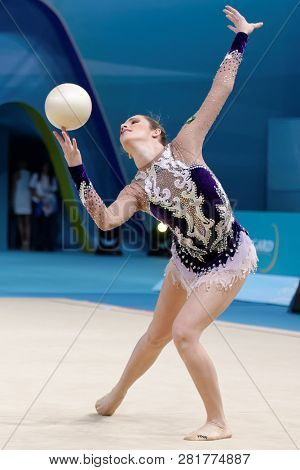 KIEV, UKRAINE - AUGUST 28, 2013: Natalia Azevedo Gaudio, Brazil performs with ball during 32nd Rhythmic Gymnastics World Championships. The event is held in Palace of Sport