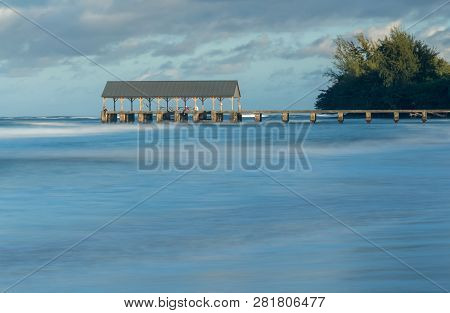 Sunrise Lights The Dawn Sky Above Hanalei Pier With Long Duration Exposure To Blur Waves Near Hanale