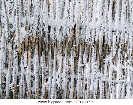 Snowbound fence closeup texture background.