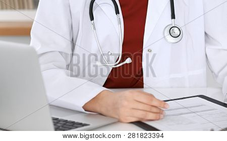 Close-up Of A Unknown Female Doctors Hands. Physician At Working Place Ready To Consult And Halp Pat
