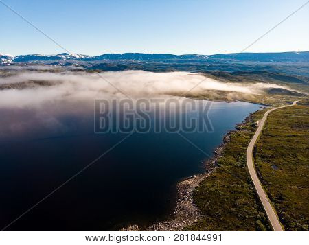 Aerial View. Road Crossing Hardangervidda Mountain Plateau, Clouds Over Lakes, Morning Time. Norway 